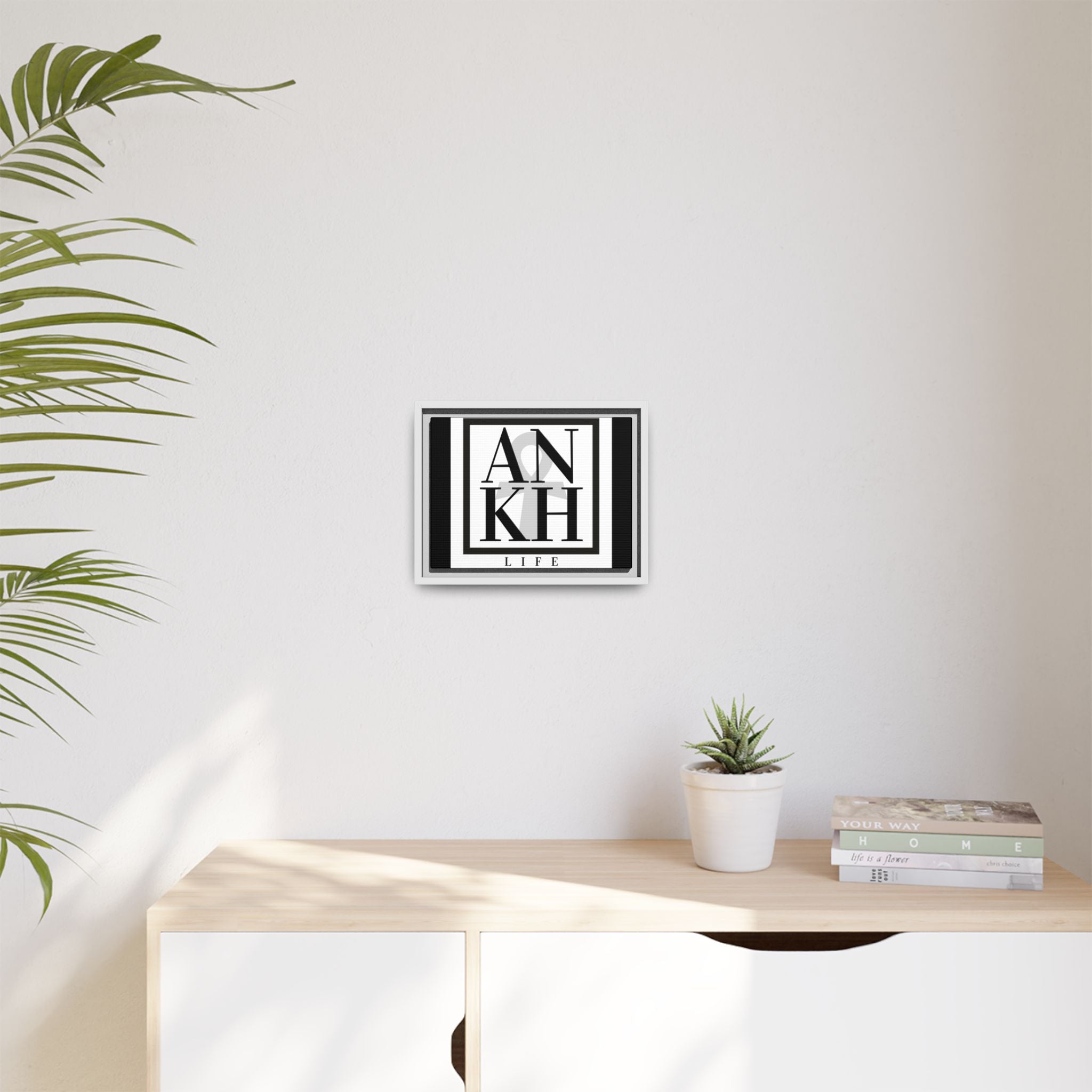 White-framed ANKH Life Canvas Artwork in bright room with minimalist décor. Sustainable spiritual art print for stylish home interiors.
